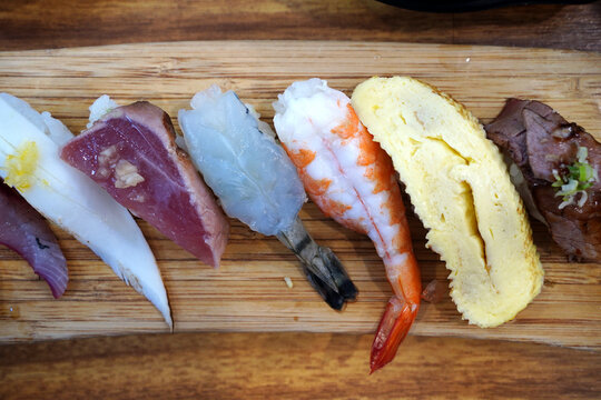 Top view of assorted premium sushi platter on a wooden board
