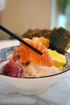 Japanese kaisendon seafood rice bowl topped with salmon, tuna, shrimp tempura, and tamago