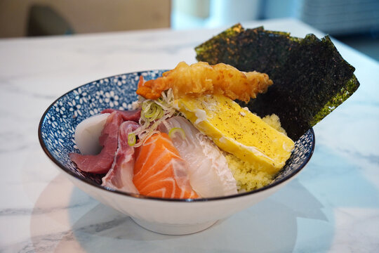 Japanese kaisendon seafood rice bowl topped with salmon, tuna, shrimp tempura, and tamago
