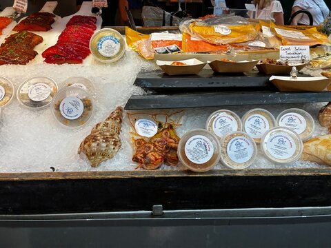 Abundant display of fresh seafood at a London fish market stall: Salmon (Salmo salar), Cod, Lobsters (Homarus gammarus), Scallops, Octopus on ice. Healthy organic food.