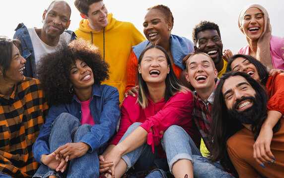 Group of happy multiracial people having fun together outdoor - Crowd of young friends with different ethnic smiling on camera - Community, humanity and social inclusion concept