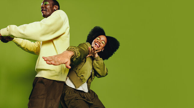 Playful friends dance together in the studio with youthful energy and rhythm