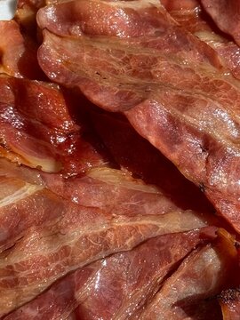 Bacon crujiente cocinado en primer plano durante el desayuno fondo de pantalla