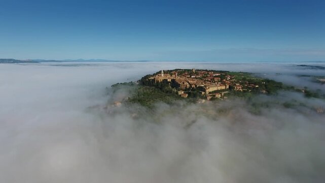 Aerial view of Pienza rising above morning fog in the rolling hills, Pienza, Tuscany, Italy.