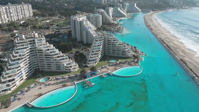 Aerial view of San Alfonso del Mar resort with its massive turquoise swimming pool and modern apartment buildings along the coast in Algarrobo, Valparaiso, Chile.