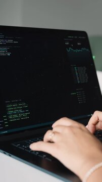 Female programmer typing code on laptop computer