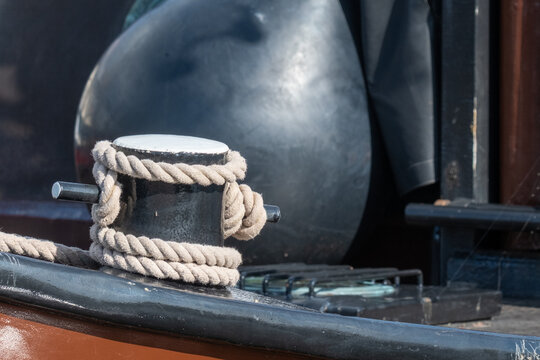 Boat equipment is secured with rope at the dock during daylight hours near the water