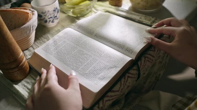 young conservative asian Woman Reading the Bible at table with bread food and drink indoors	
