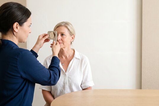 Optometrist swings the lens into place the moment the customer's eyes refocus, eye examination in an optical practice with copy space