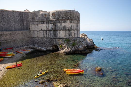 Dubrovnik, Croatia - 12 August 2018: View of Bokar Fortress with colorful kayaks in the clear Adriatic Sea waters along the historic city walls.