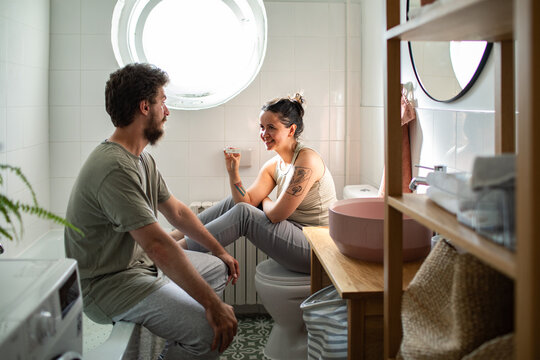 Young couple talking during morning routine in home bathroom