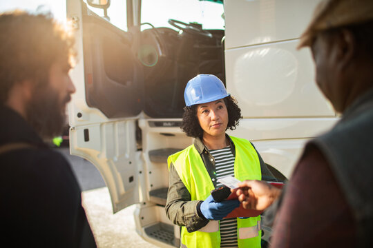 Safety inspector checking truck driver id at logistics yard