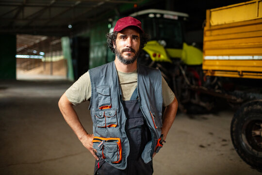 Portrait of confident farmer mechanic in tractor workshop
