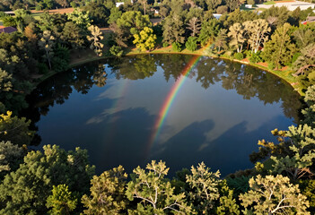 Obraz premium Nature conservation and environmental beauty, double rainbow over a calm forest lake reflecting lush green trees in a peaceful woodland landscape