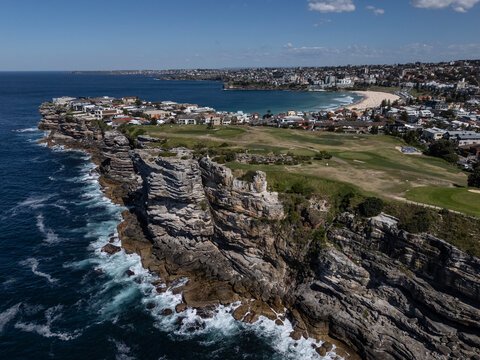 Bondi, Sydney cliffs, ocean and coastline on beautiful sunny spring day from aerial drone view. Bondi Beach can be seen in the distance