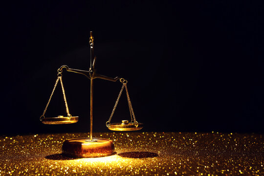 Golden scales on dark background. Idea of balance and law