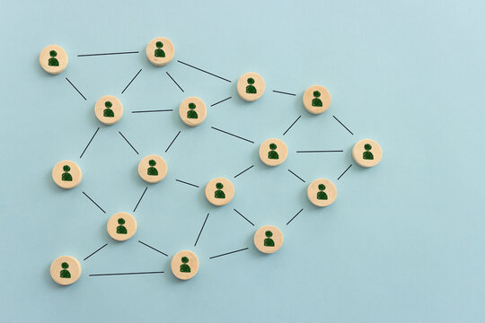 Wooden cubes with people icons over pastel background, human resources and management concept
