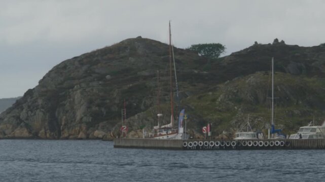A dock to a port by a rocky coast.