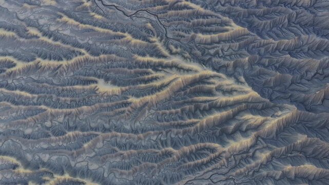 Aerial view of eroded badlands with intricate ridges and dry drainage patterns in the desert landscape in Hanksville, Utah, United States.
