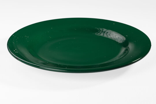 Empty dark green plate isolated on white background