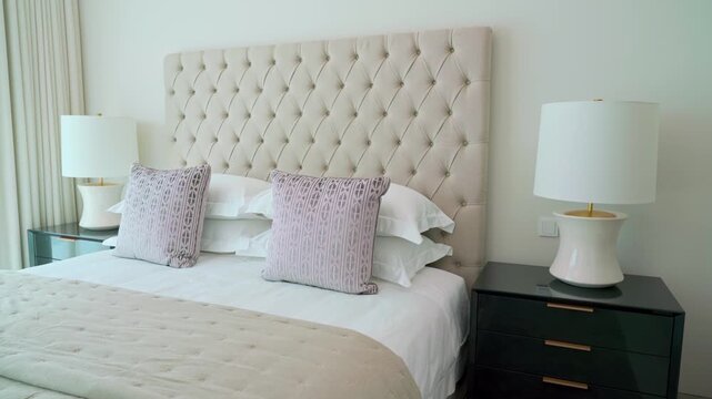 Luxurious master bedroom showcasing a contemporary interior with a king size bed, elegant tufted headboard, and stylish bedside tables with modern lamps for a comfortable and tranquil retreat