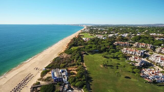Beautiful aerial view of praia de garrao beach and the luxury vale do lobo resort in algarve, portugal, with the turquoise atlantic ocean and a clear blue sky on a sunny summer day