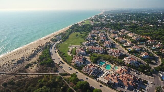 Beautiful aerial view of the praia de garrao beach and the vale do lobo luxury resort in algarve, portugal, with its iconic villas and swimming pools nestled along the atlantic ocean coast