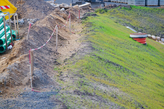 Construction site with earthworks and green grass slope under development