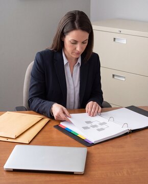 Compliance officer reviews audit evidence binder in office