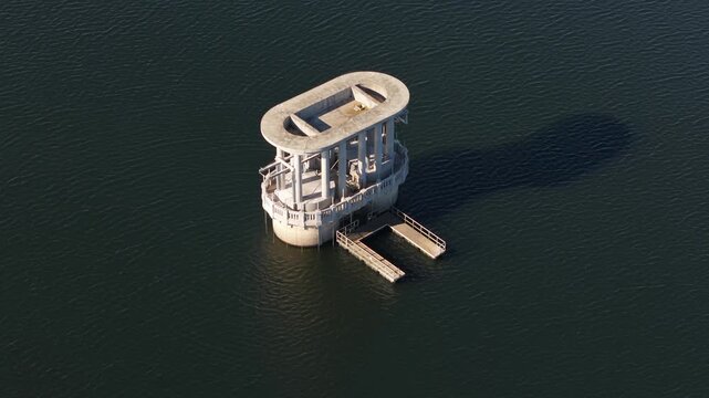 Silvan, Victoria, Australia - 01 September 2026: Aerial view of the concrete intake tower at Silvan Reservoir Park surrounded by calm water.