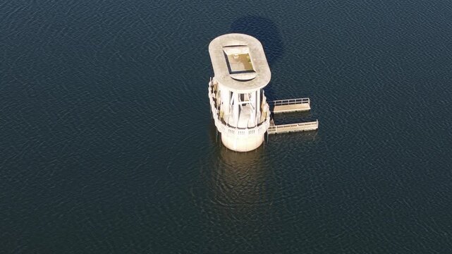 Silvan, Australia - 01 September 2026: Aerial view of the concrete intake tower at Silvan Reservoir Park surrounded by calm dark water with gentle ripples.