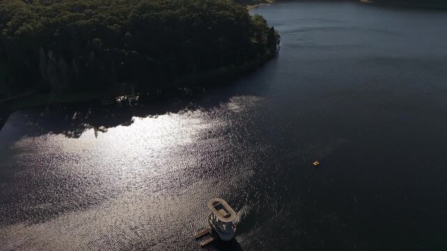 Silvan, Australia - 01 September 2026: Aerial view of Silvan Reservoir Park with its distinctive intake tower rising from the dark water, surrounded by dense forest and shimmering sunlight.