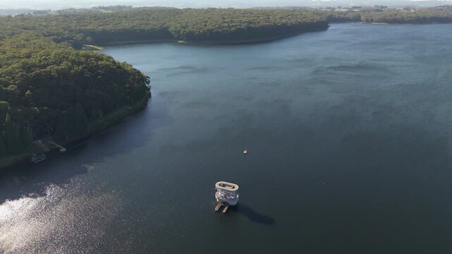 Silvan, Australia - 01 September 2026: Aerial view of Silvan Reservoir Park with its concrete intake tower surrounded by dense forest and calm water.