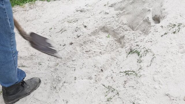 Working on sand pile with shovel and care