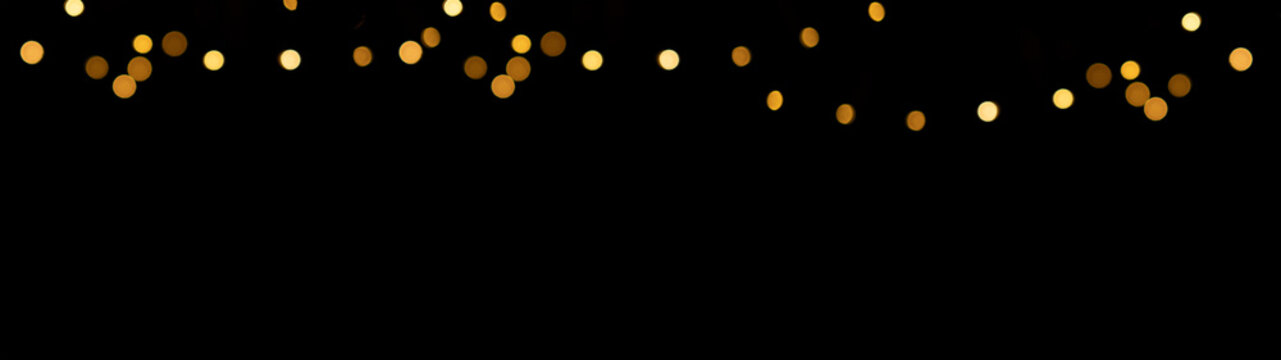 Glowing overlay banner panorama texture - hanging defocused fairy lights bokeh lights, isolated on black background	
