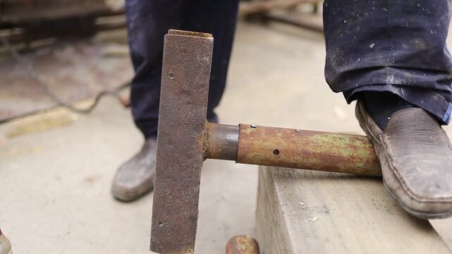 Man using a tool to shape wood in a workshop