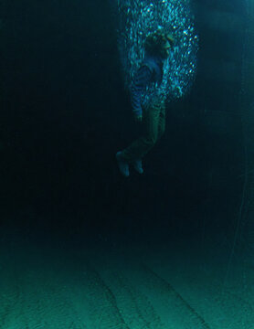 Middle aged man in casual wardrobe under water in ocean. 3D rendered still image.