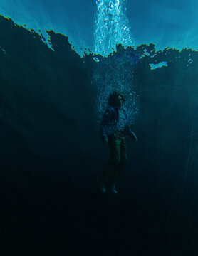 Middle aged man in casual wardrobe under water in ocean. 3D rendered still image.