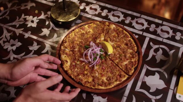Lahmacun, a traditional Turkish and Arabic dish, served on a wooden plate in a restaurant