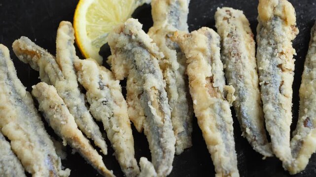 Close-up of fresh European anchovies, also known as boquerones, a popular small fish in Spain. Traditional Spanish tapas featuring fresh anchovies and Mediterranean seafood. High quality 4k footage