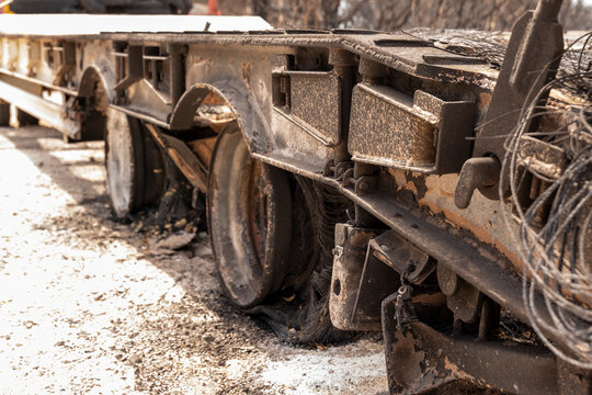 Charred truck trailer chassis with damaged wheels after intense fire