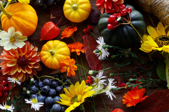 Happy Thanksgiving. Pumpkins, autumn leaves, berries and flowers border on old wooden table flat lay. Atmospheric fall still life. Fall season banner