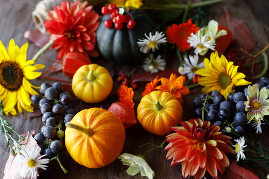Happy Thanksgiving. Pumpkins, autumn leaves, berries and flowers border on old wooden table flat lay. Atmospheric fall still life. Fall season banner