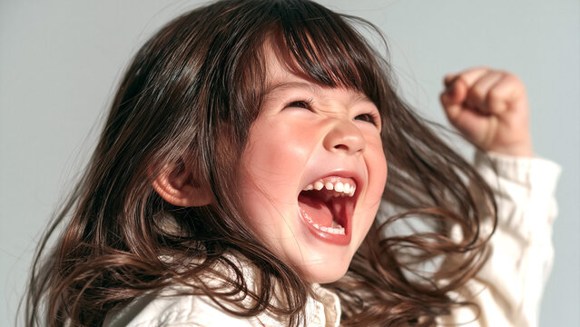 満面の笑みで両手を握りしめて大喜びする小さな女の子の空間背景
