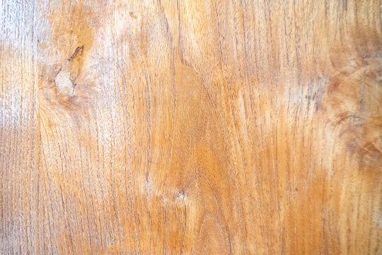 Warm light brown wood surface featuring a natural vertical grain pattern and clearly visible knots. It consists of wood planks polished or varnished suitable for furniture or interior surfaces.