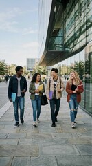 Obraz premium Diverse college students walking and laughing on a modern campus during the day