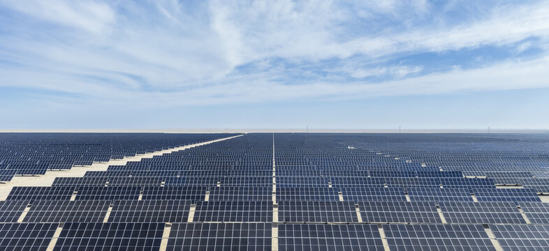 Aerial View of Endless Solar Panel Array Stretching Across Vast Desert Landscape