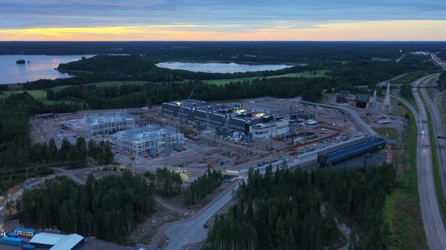 Aerial view of the data center construction site with cranes and machinery surrounded by forest and lakes in Espoo, Uusimaa, Finland.