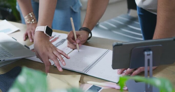 After sketch review, designers are aligning fabric and noting in notepad on table for final design