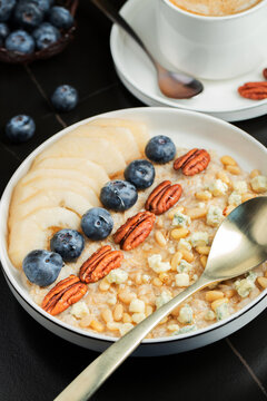 Oatmeal. Bowl of oatmeal porridge with blackberry, bananas and chia seeds on gray concrete old table background. Top view in flat lay style. Natural ingredients. Hot healthy breakfast and diet food